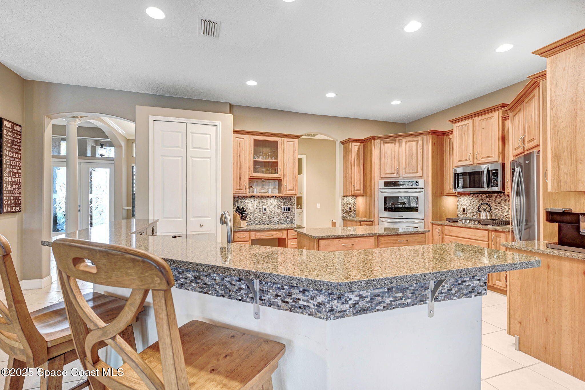 8082 Old Tramway Drive Melbourne, FL 32940 - Photo 21 of 82 a large kitchen with kitchen island granite countertop a large counter top stainless steel appliances and cabinets
