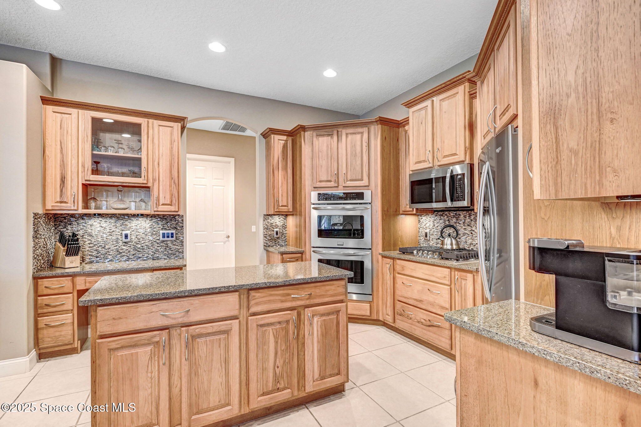 8082 Old Tramway Drive Melbourne, FL 32940 - Photo 25 of 82 a kitchen with stainless steel appliances granite countertop a stove a sink and a refrigerator