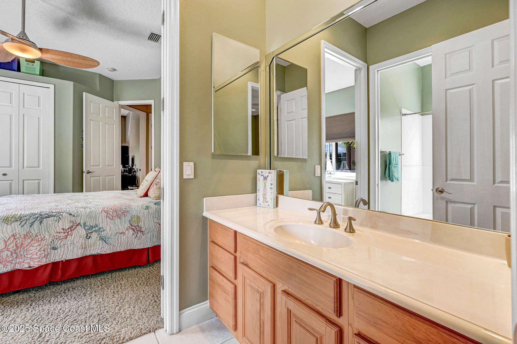 8082 Old Tramway Drive Melbourne, FL 32940 - Photo 37 of 82 a en suite bathroom with a sink and a large mirror