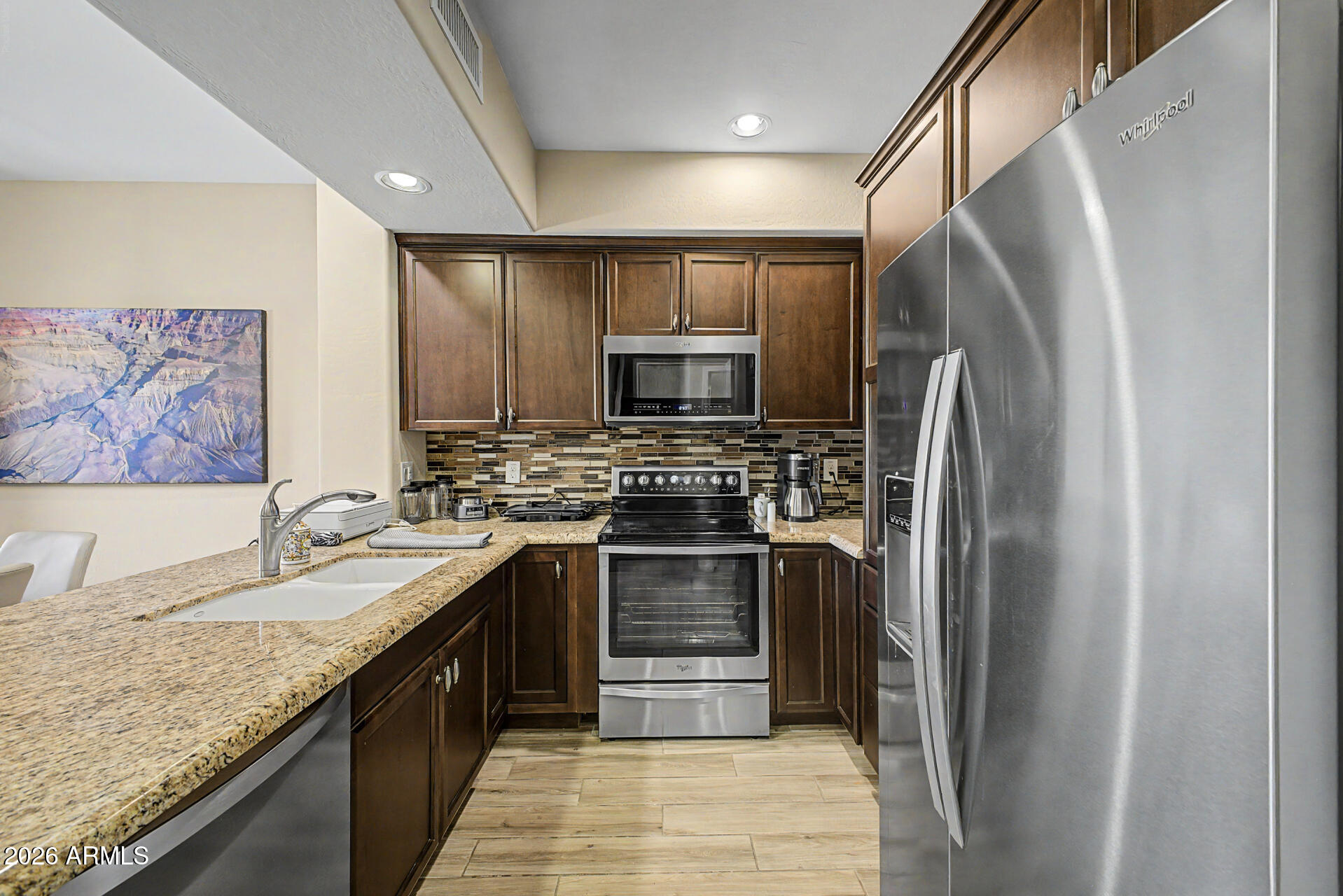 3935 East Rough Rider Road, Unit 1373 Phoenix, AZ 85050 - Photo 12 of 48 a kitchen with stainless steel appliances granite countertop a refrigerator and a sink