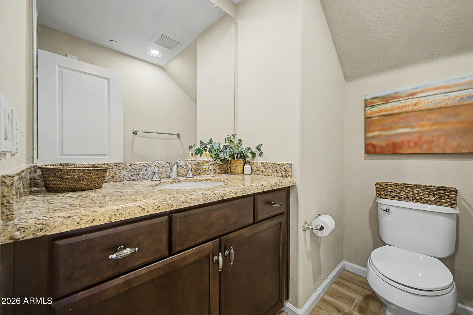 3935 East Rough Rider Road, Unit 1373 Phoenix, AZ 85050 - Photo 15 of 48 a bathroom with a granite countertop toilet sink and mirror