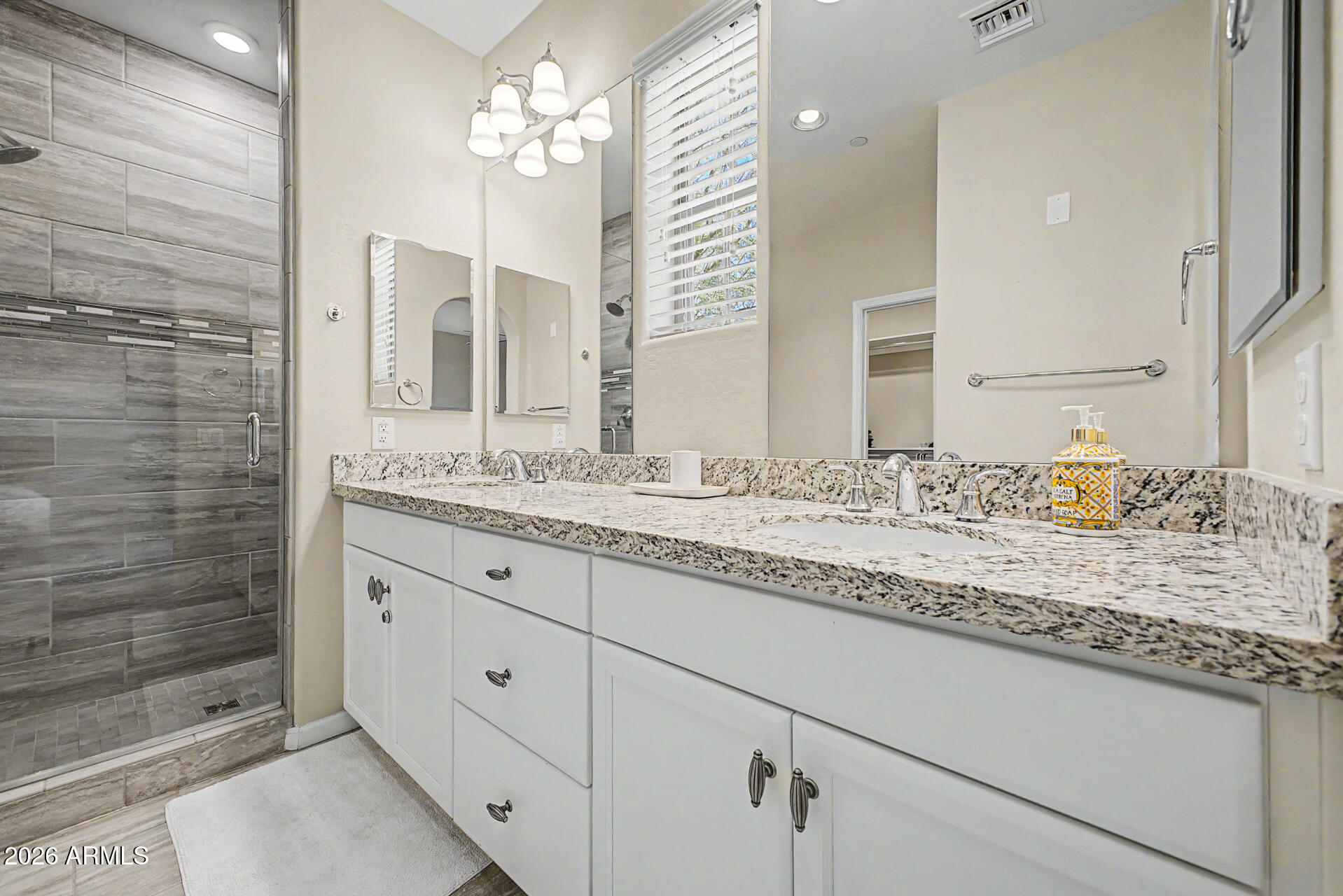 3935 East Rough Rider Road, Unit 1373 Phoenix, AZ 85050 - Photo 18 of 48 a bathroom with a granite countertop sink a mirror and a shower