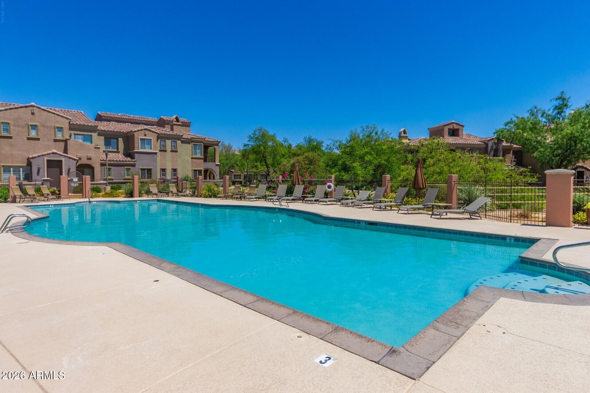 3935 East Rough Rider Road, Unit 1373 Phoenix, AZ 85050 - Photo 41 of 48 a view of a swimming pool with a lawn chairs