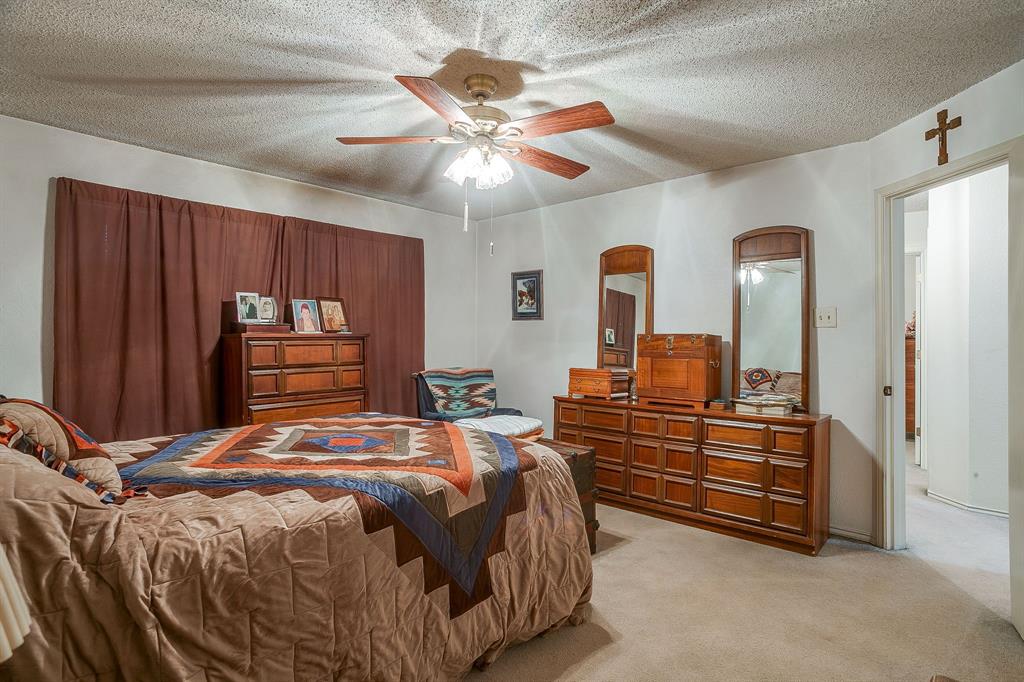 1086 Rock Ridge Drive Burleson, TX 76028 - Photo 22 of 40 a bedroom with a bed and a chandelier