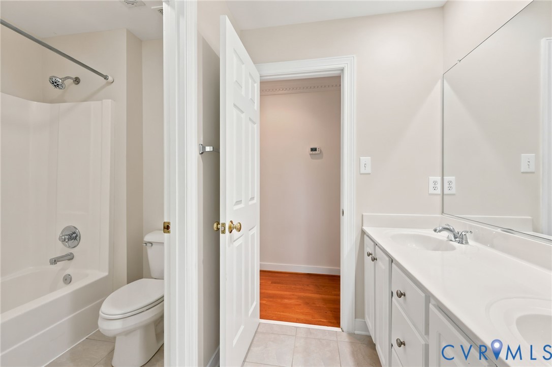4701 Regal Oaks Road Glen Allen, VA 23059 - Photo 33 of 60 a bathroom with a double vanity sink toilet mirror and bathtub