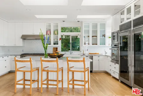 a kitchen with stainless steel appliances kitchen island granite countertop a table and chairs in it