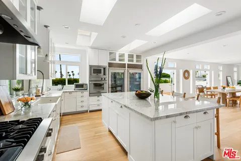 a view of a kitchen with kitchen island granite countertop lots of counter top space and living room