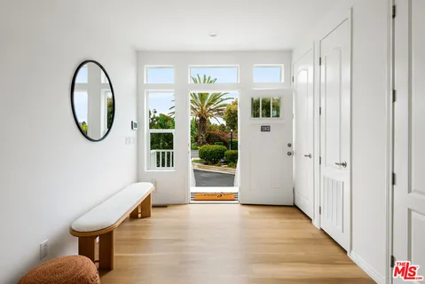 a view of a hallway with wooden floor and entryway