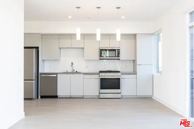 a kitchen with stainless steel appliances granite countertop a sink and a stove