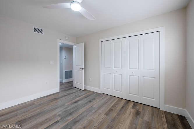 140 Cypress Way East, Unit 601 Naples, FL 34110 - Photo 18 of 27 an empty room with wooden floor and closet area