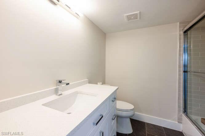 140 Cypress Way East, Unit 601 Naples, FL 34110 - Photo 19 of 27 a bathroom with a sink a toilet and shower