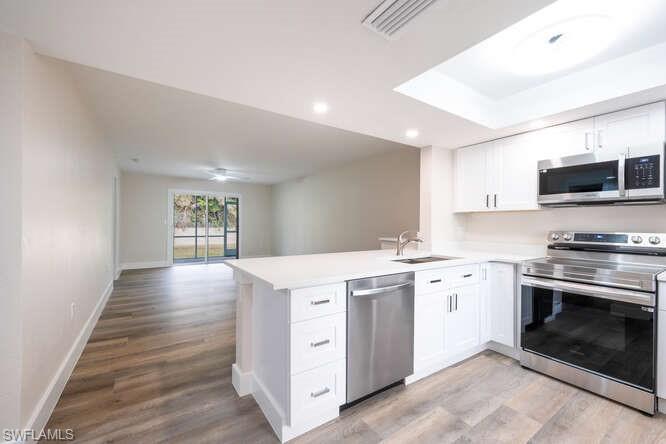 140 Cypress Way East, Unit 601 Naples, FL 34110 - Photo 2 of 27 a kitchen with a stove top oven and sink