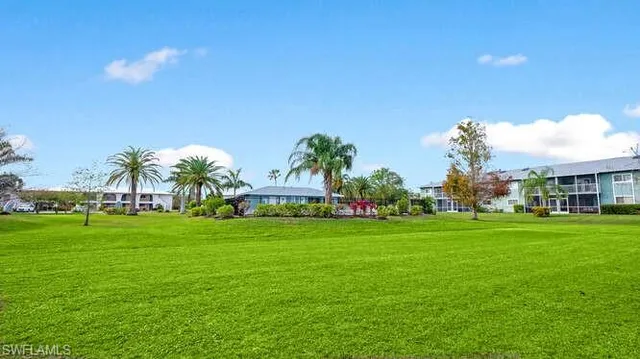 a front view of a house with a yard and trees