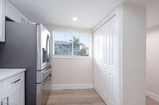 a view of cabinets with stainless steel appliances wooden floor and window