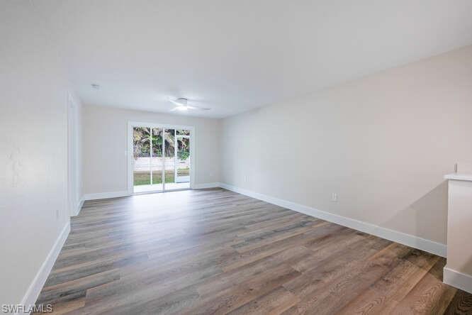 140 Cypress Way East, Unit 601 Naples, FL 34110 - Photo 7 of 27 wooden floor in an empty room with a window