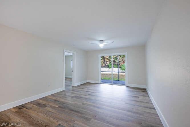 140 Cypress Way East, Unit 601 Naples, FL 34110 - Photo 8 of 27 a view of an empty room with wooden floor and a window