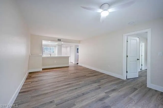 a view of empty room with wooden floor