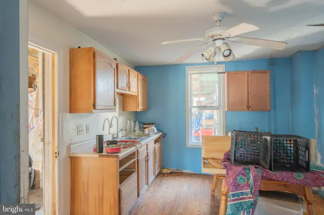 a kitchen that has a lot of cabinets and wooden floor