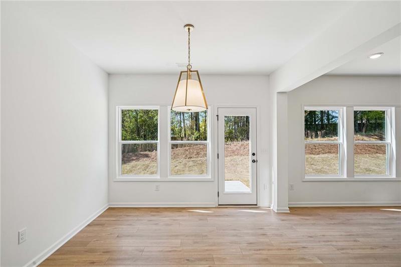 240 Silverleaf Trail Bethlehem, GA 30620 - Photo 10 of 35 a view of an empty room with wooden floor and a window