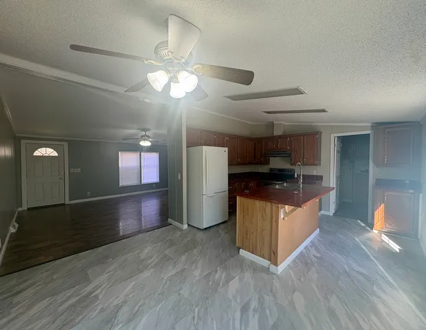 a kitchen with stainless steel appliances granite countertop a refrigerator a stove and a wooden floors