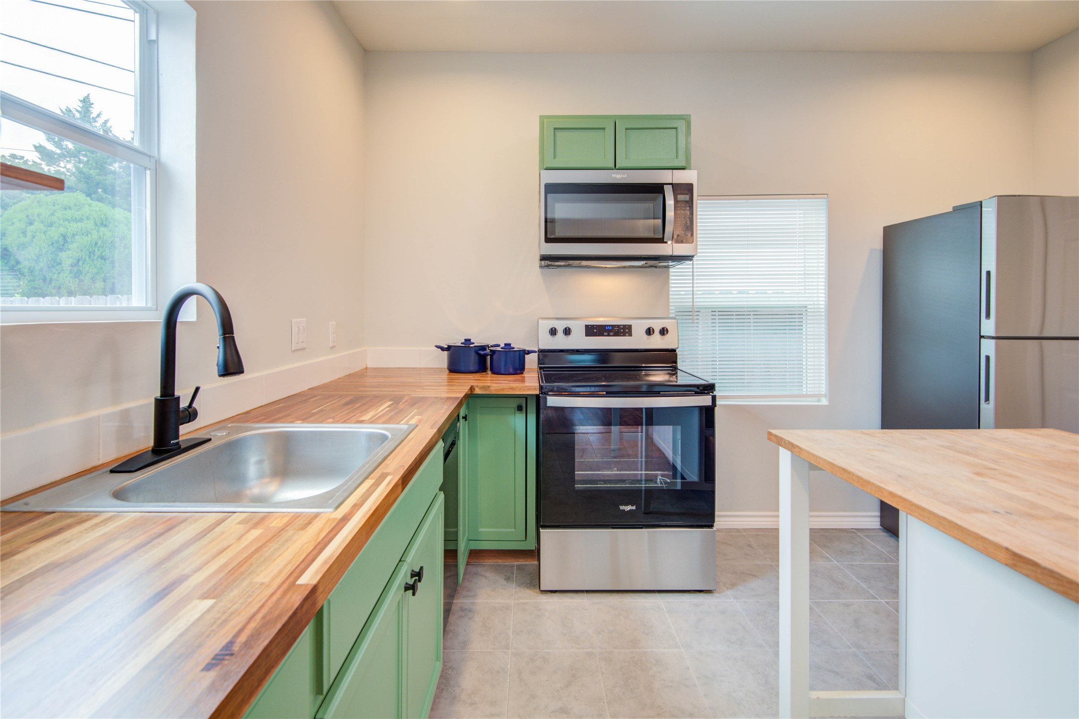 2712 Link Road Houston, TX 77009 - Photo 12 of 35 a kitchen with kitchen island stainless steel appliances a sink stove and refrigerator