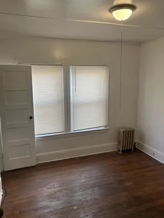 a view of room with window and wooden floor