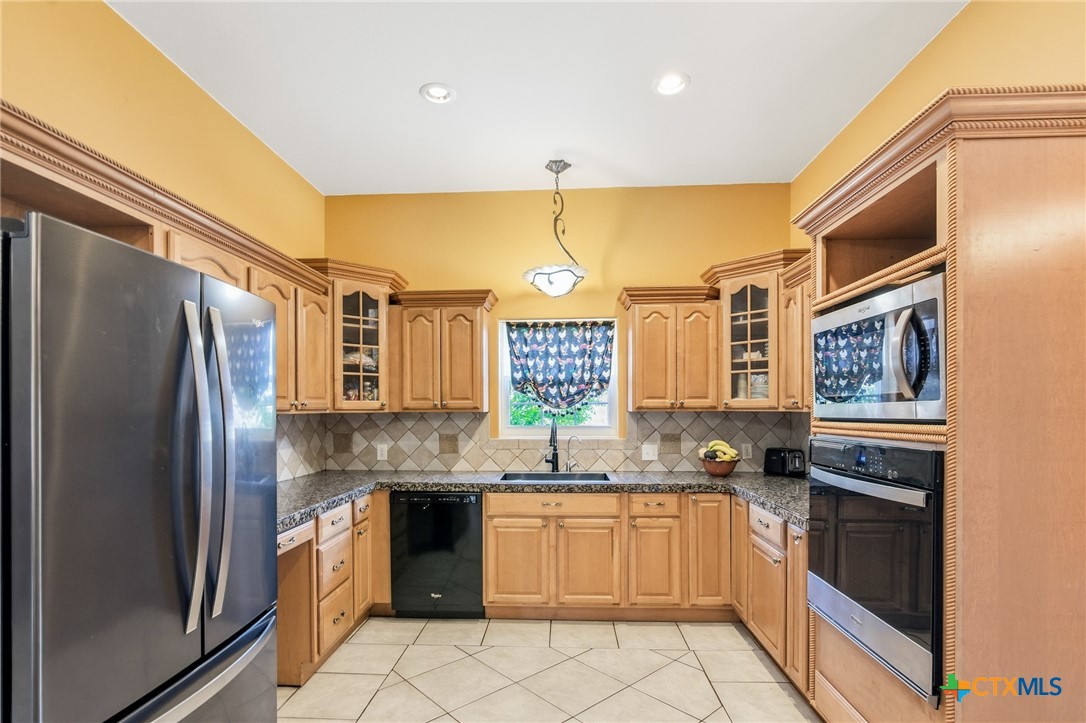 1739 Old Goliad Road Victoria, TX 77905 - Photo 12 of 43 a kitchen with granite countertop a refrigerator and a sink