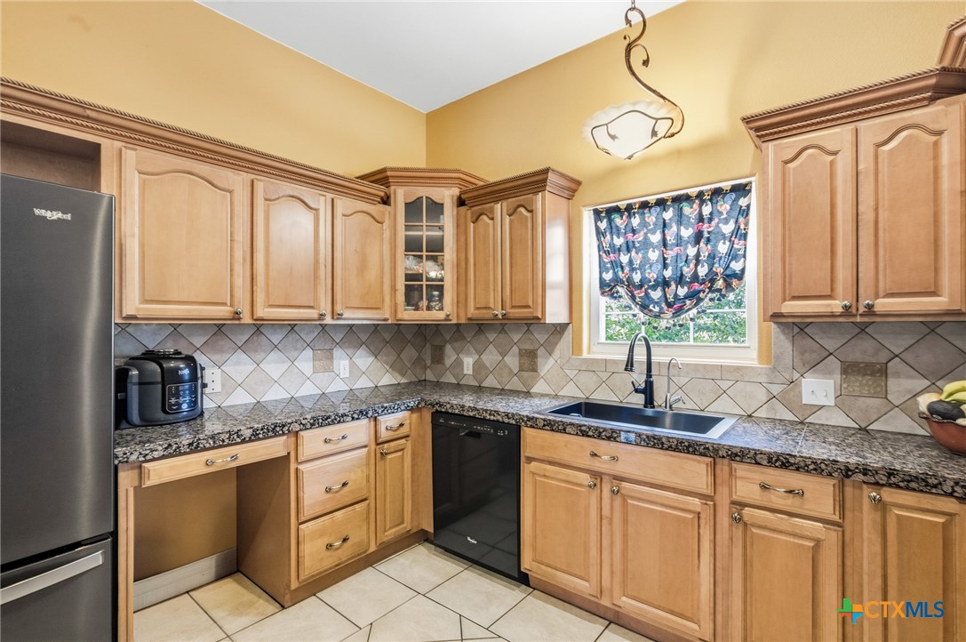 1739 Old Goliad Road Victoria, TX 77905 - Photo 16 of 43 a kitchen with stainless steel appliances granite countertop a sink a stove and cabinets