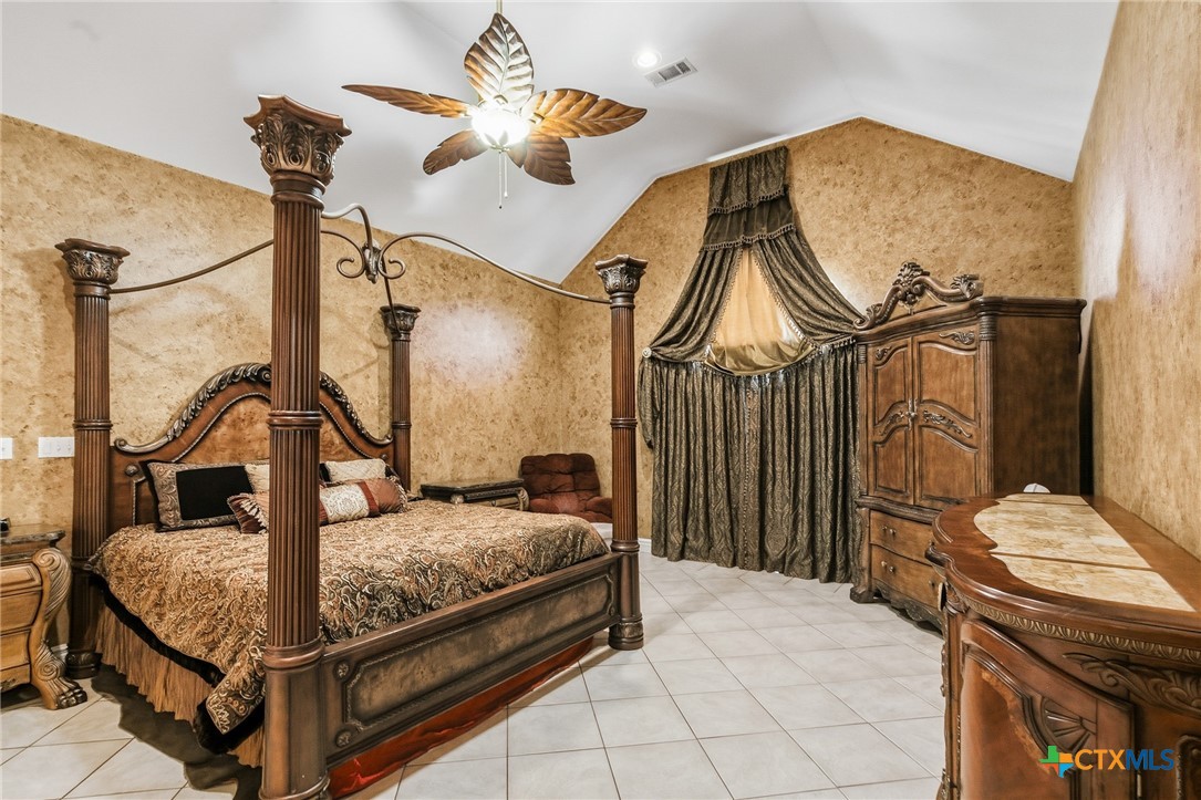 1739 Old Goliad Road Victoria, TX 77905 - Photo 18 of 43 a bedroom with a bed and a chandelier