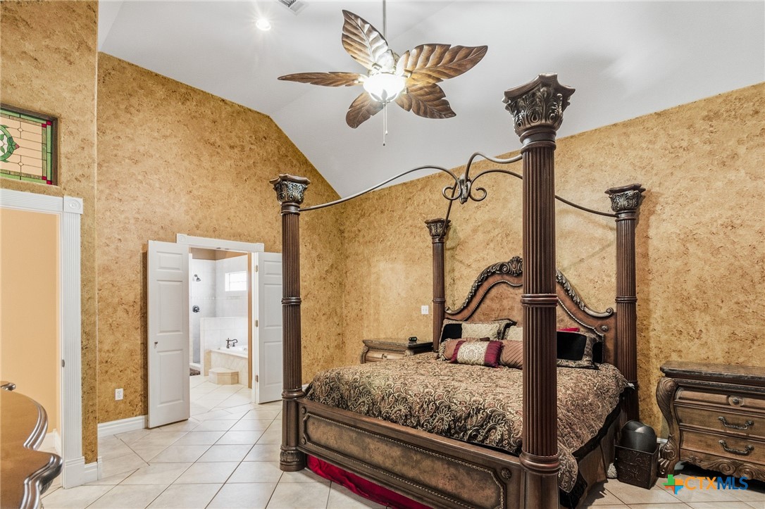 1739 Old Goliad Road Victoria, TX 77905 - Photo 19 of 43 a bedroom with a bed table and a mirror