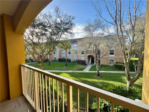 a view of a house with a yard and large trees
