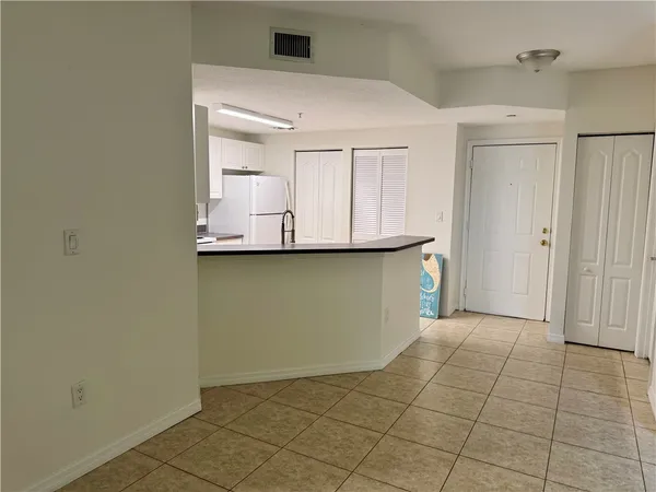 a view of a kitchen with wooden cabinets