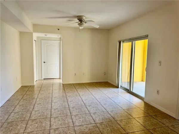 a view of an empty room with window and bathroom