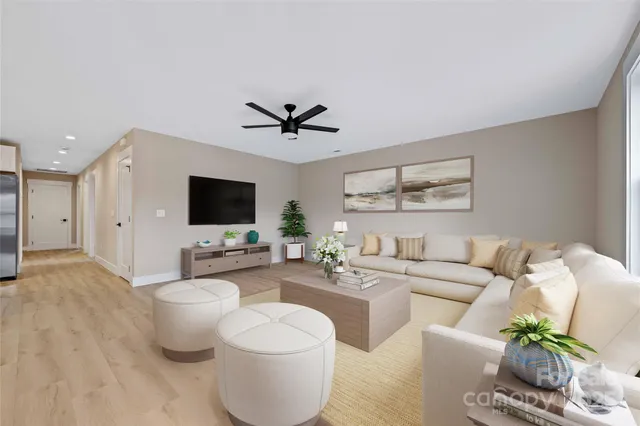 a living room with furniture a flat screen tv and a large window