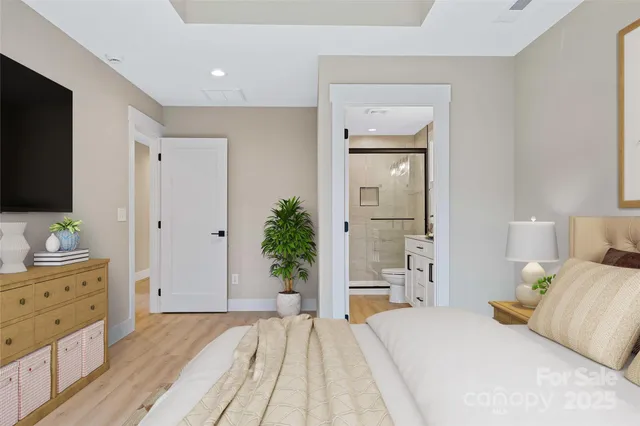 a bedroom with a large bed and a flat tv screen on dresser