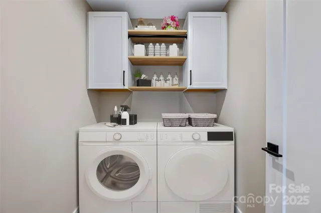 a view of washer and dryer with kitchen in the background