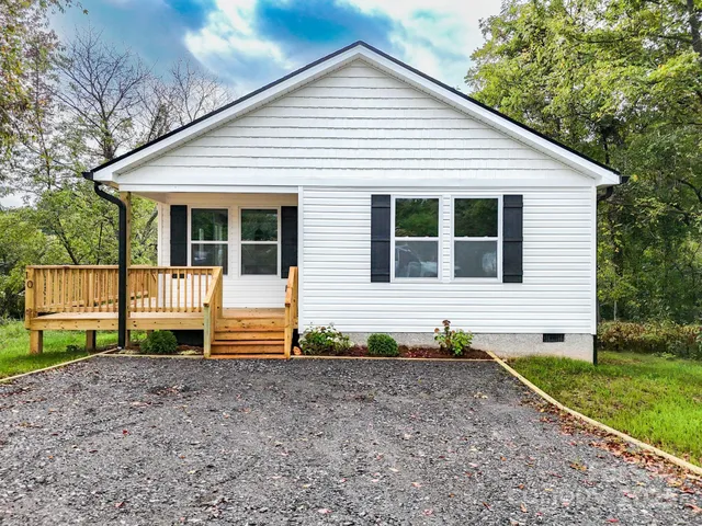 a view of a house with a yard and fence