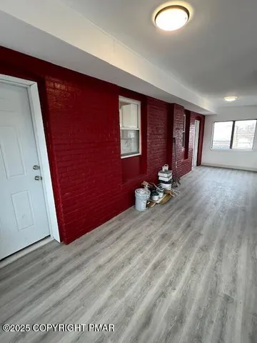 a view of empty room with wooden floor and window