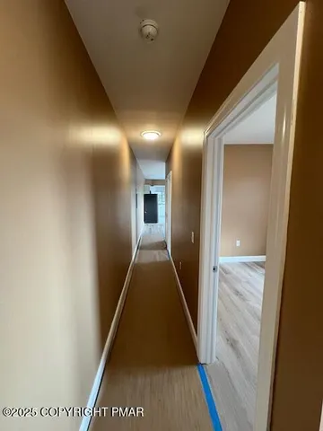 a view of a hallway with wooden floor and staircase