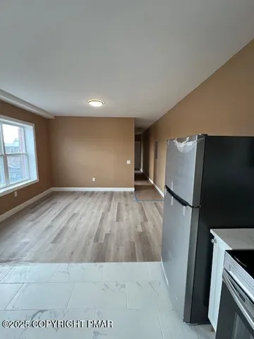 an empty room with wooden floor and cabinet