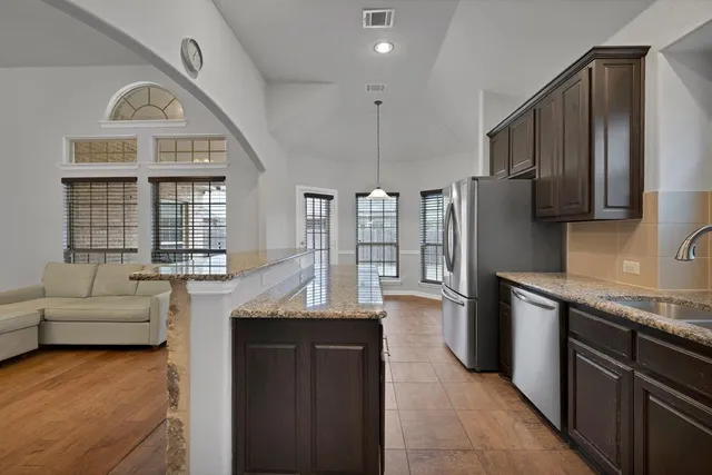 a kitchen with stainless steel appliances granite countertop a refrigerator and a sink