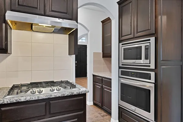 a stove top oven sitting inside of a kitchen