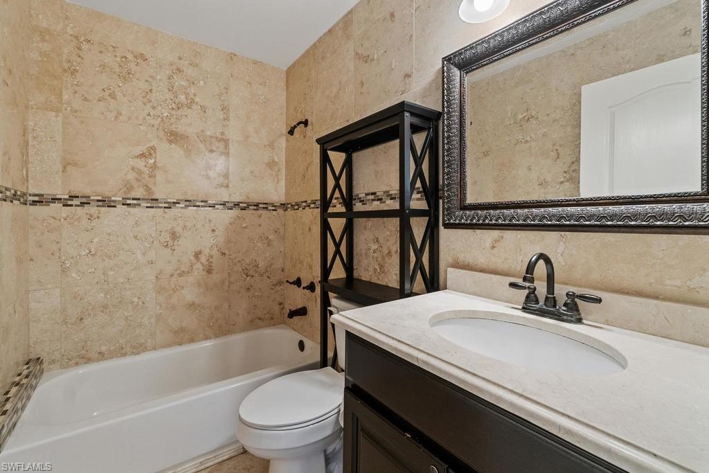 560 Henley Drive Naples, FL 34104 - Photo 13 of 16 a bathroom with a sink a toilet and a bathtub