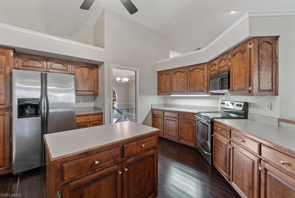 560 Henley Drive Naples, FL 34104 - Photo 7 of 16 a kitchen with stainless steel appliances granite countertop a sink stove and refrigerator