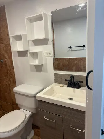 a white toilet sitting next to a bathroom sink