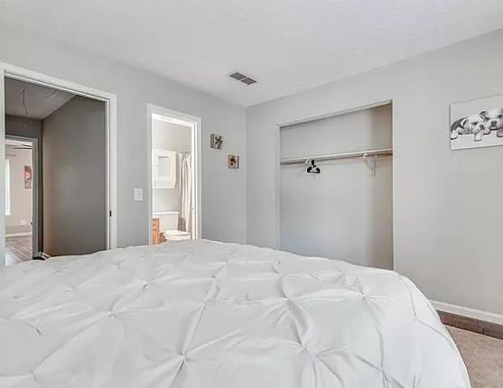 1565 Springleaf Court Southeast Smyrna, GA 30080 - Photo 12 of 23 a bedroom with a large bed and a chandelier