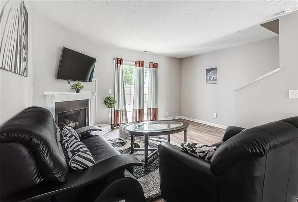 1565 Springleaf Court Southeast Smyrna, GA 30080 - Photo 7 of 23 a living room with furniture a flat screen tv and a fireplace