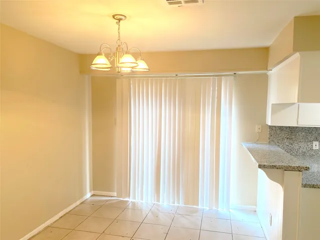 a view of a kitchen with granite countertop cabinets and a chandelier