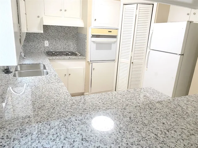 a kitchen with a refrigerator sink stove and cabinets