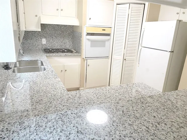 a kitchen with a refrigerator sink stove and cabinets